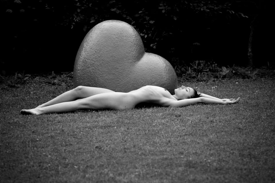 A second frame at the stone heart, the figure stretched parallel to the plinth
