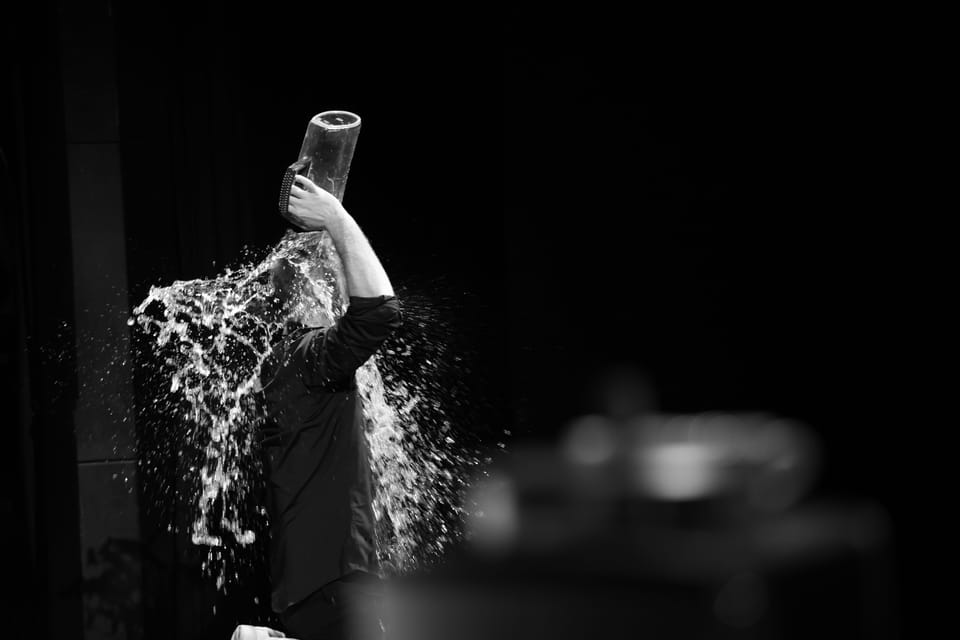 Water thrown from a glass frozen in flight against black