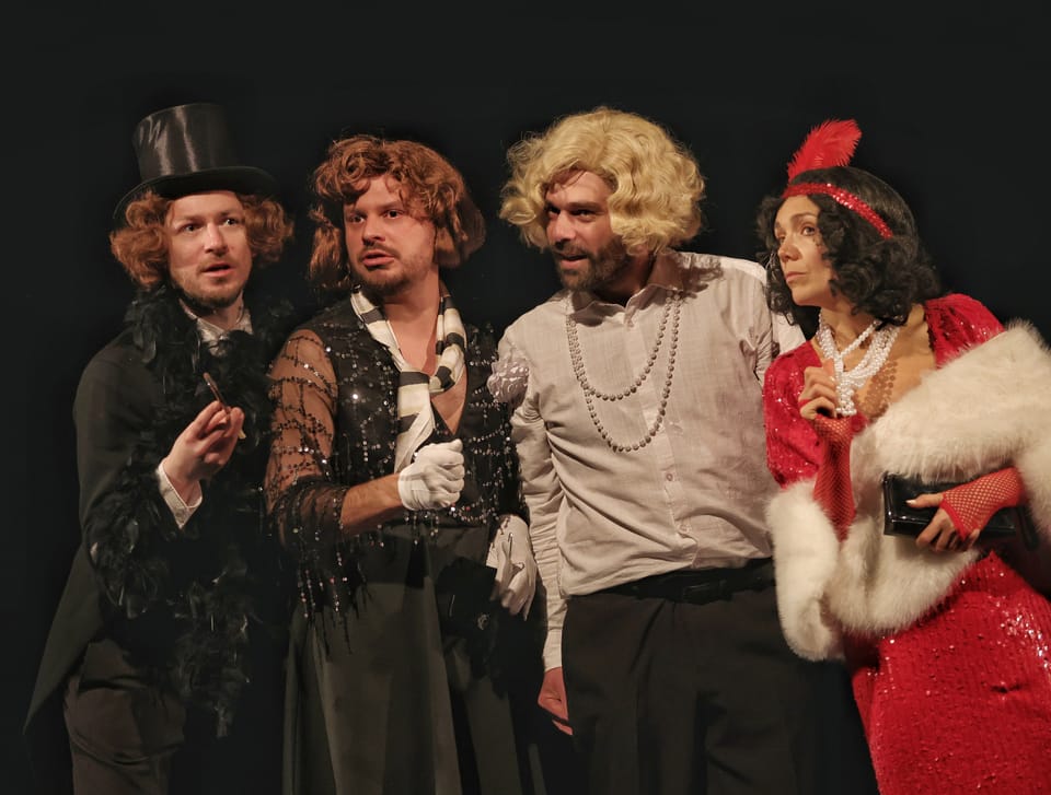 Four in period costume with a top hat and wigs, a woman in red at the right