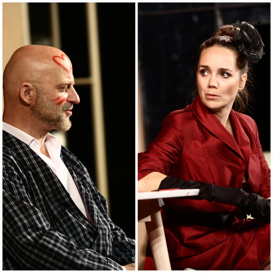 A pair on stage: a man with blood on his brow facing a woman in a red coat and black gloves