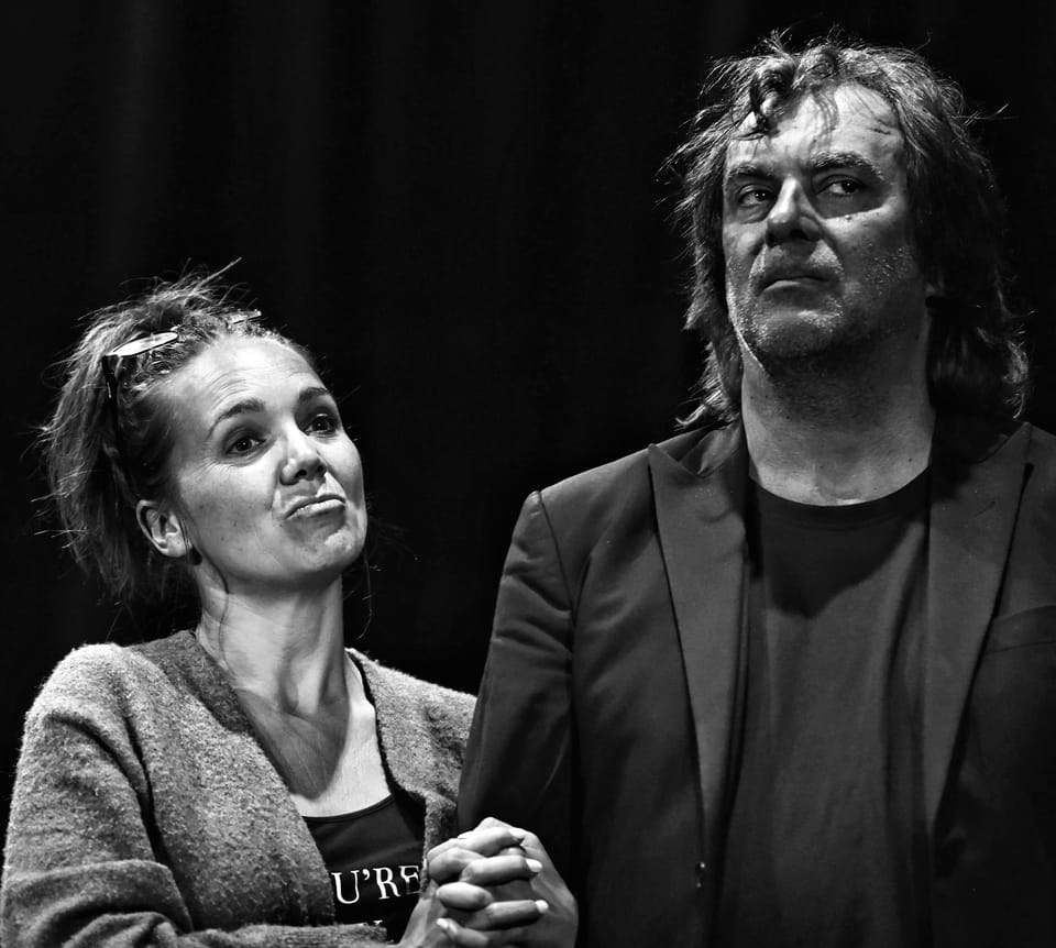 A pair in stage make-up with tangled hair close together