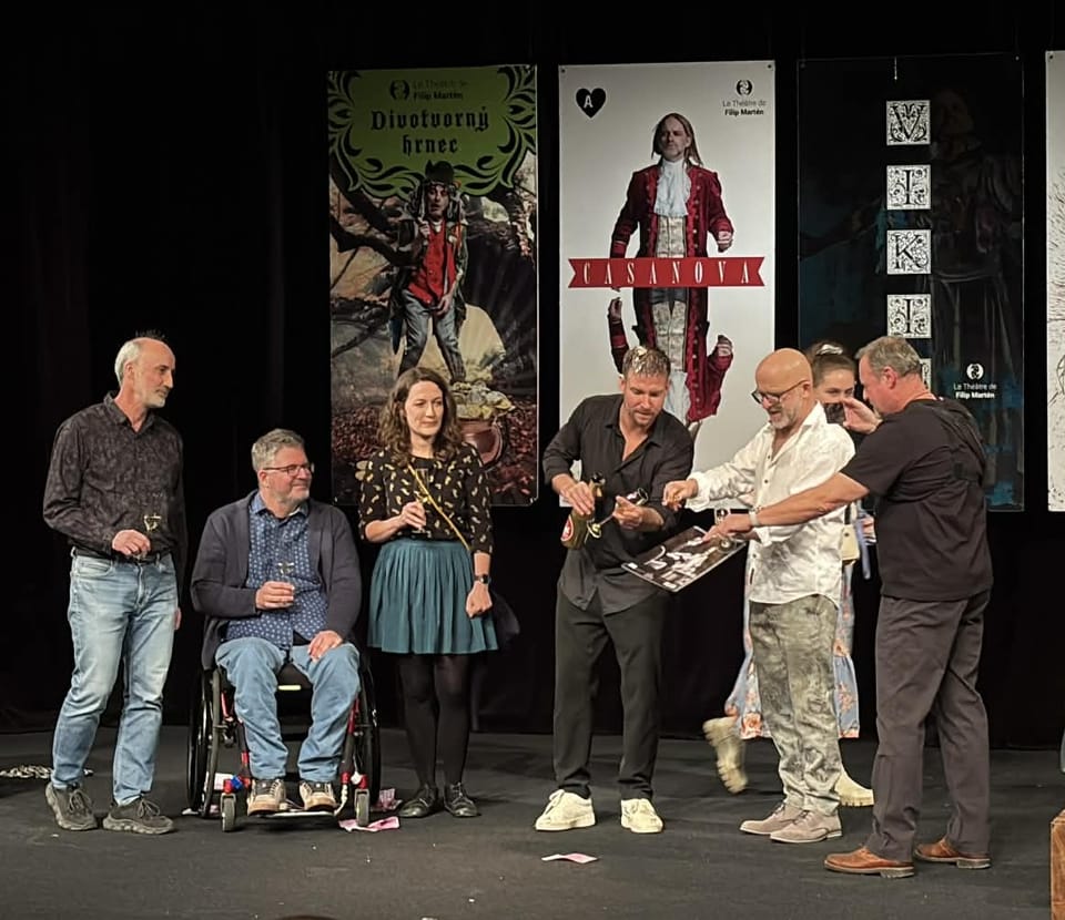 An award being presented on stage in front of theatre posters