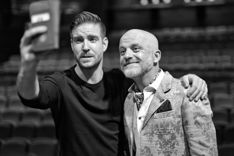 Two men taking a selfie in the empty auditorium