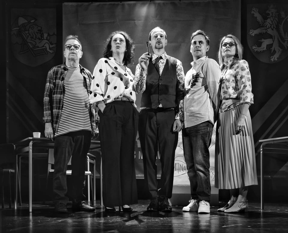 Six actors lined up on stage, one at the microphone in front