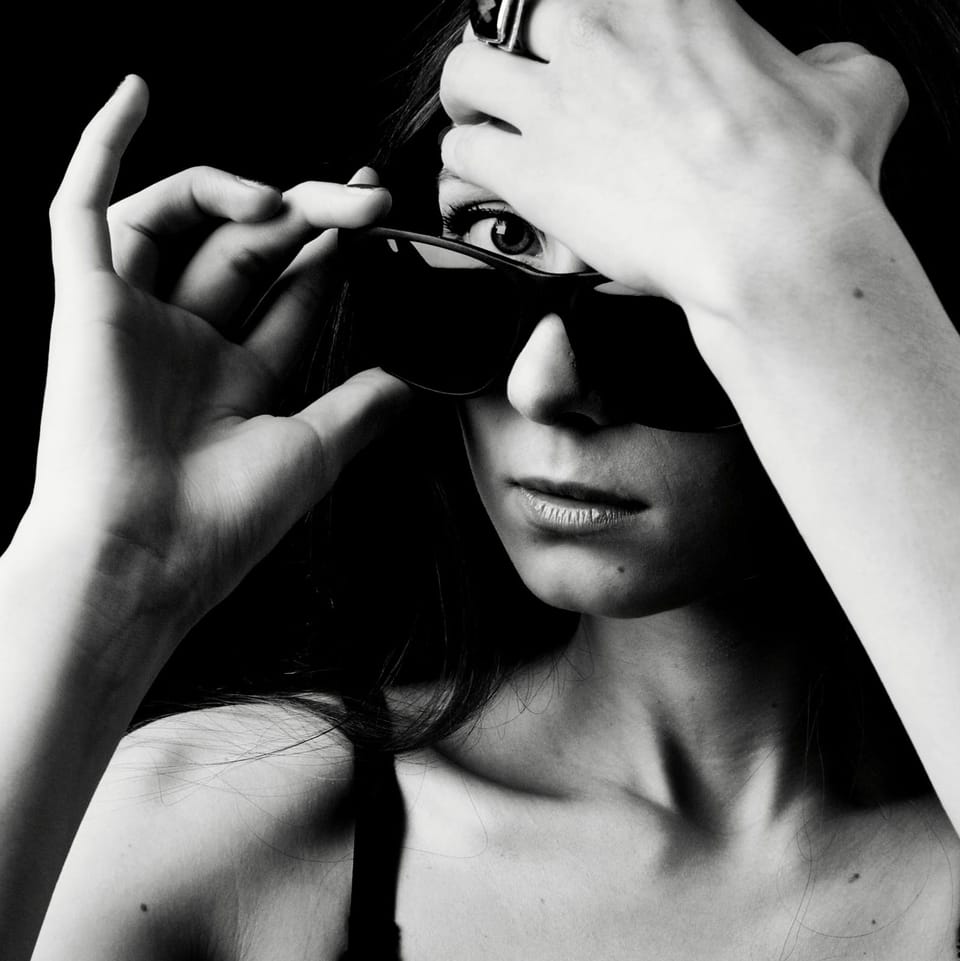 Someone else's hands pull the sunglasses from her eyes and frame her face
