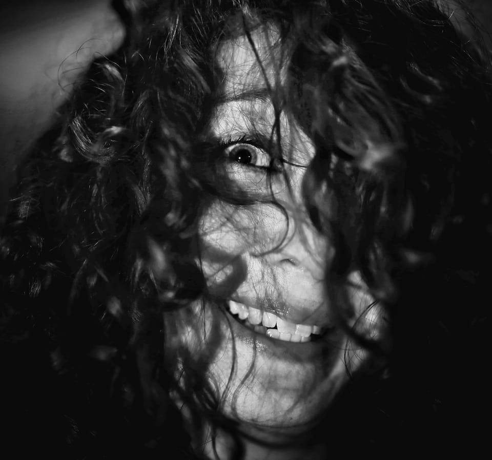 Wild laughter behind tangled hair, the darkness holding nothing else