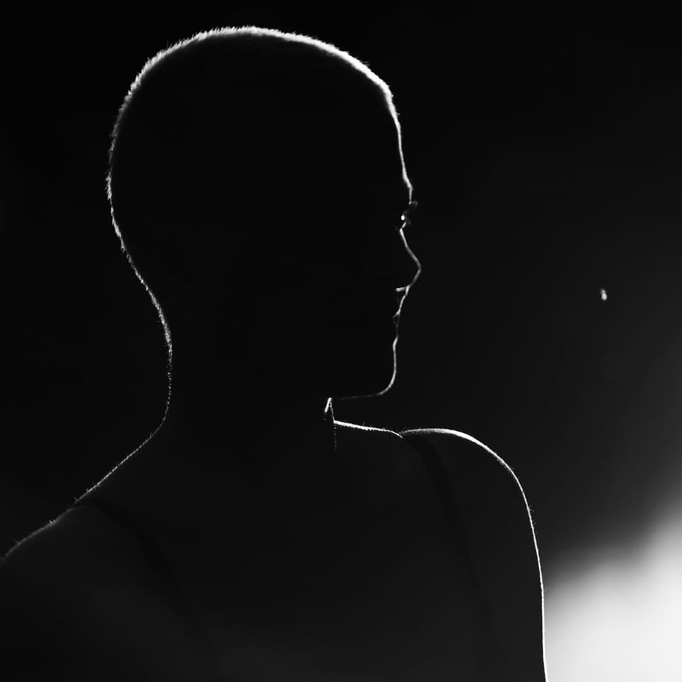 All that survives the dark is a thin line of light along head and shoulder