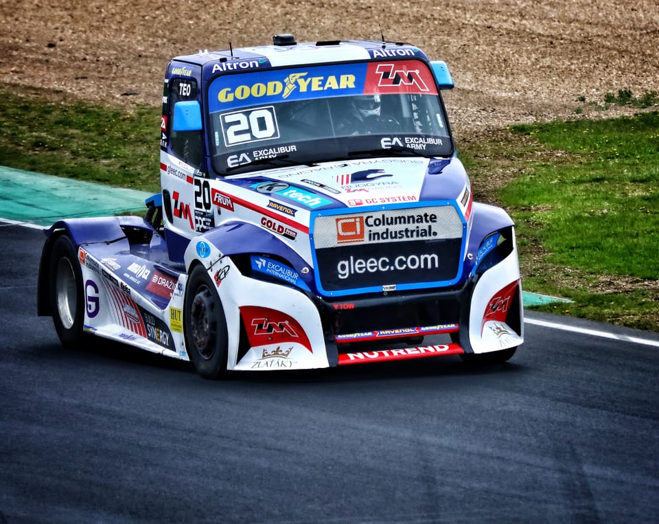 Racing truck number 20 through a circuit bend, its nose tipped to the inside