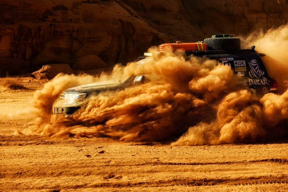 Only the car's outline shows through the dust cloud, the desert has taken the rest