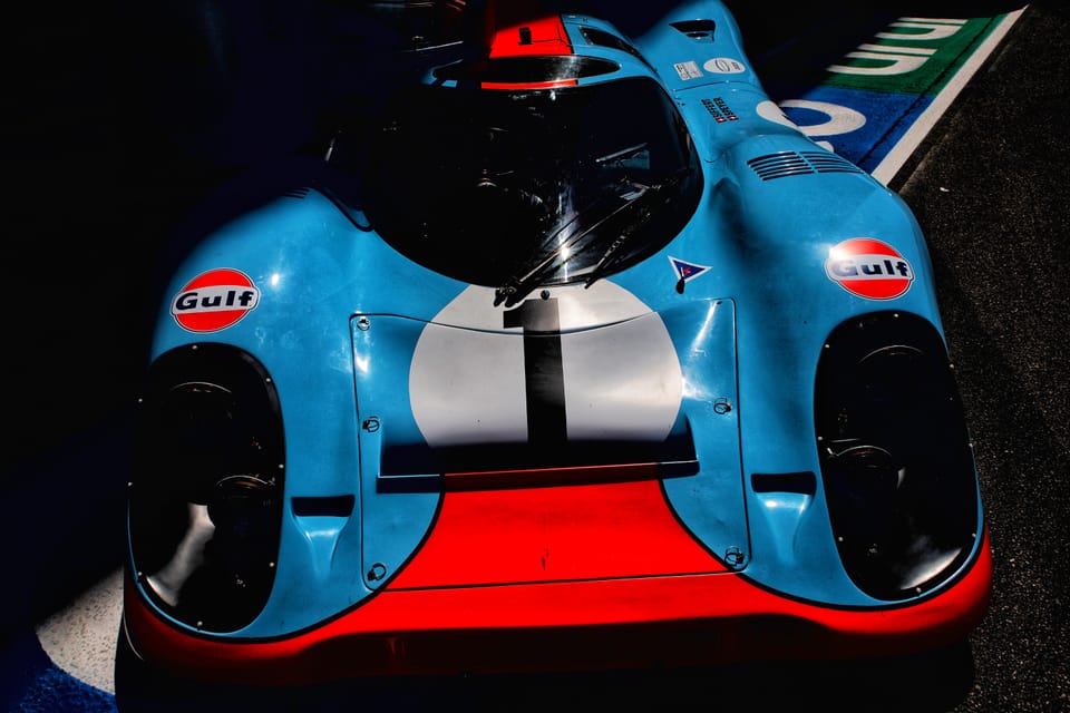 A historic Gulf-liveried Porsche race car, close on the nose and its number 1