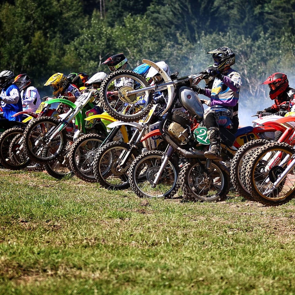 A row of bikes lined up at the start, riders beside their machines