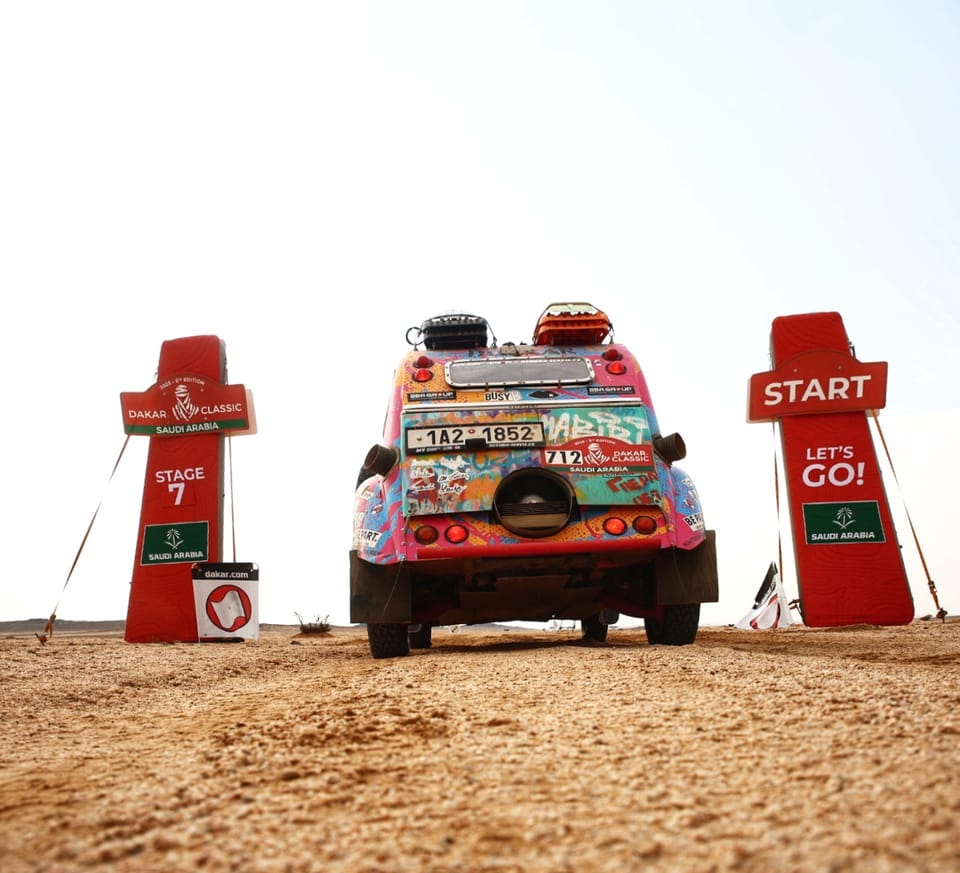 A painted car waiting in the stage start gate, red pillars to either side