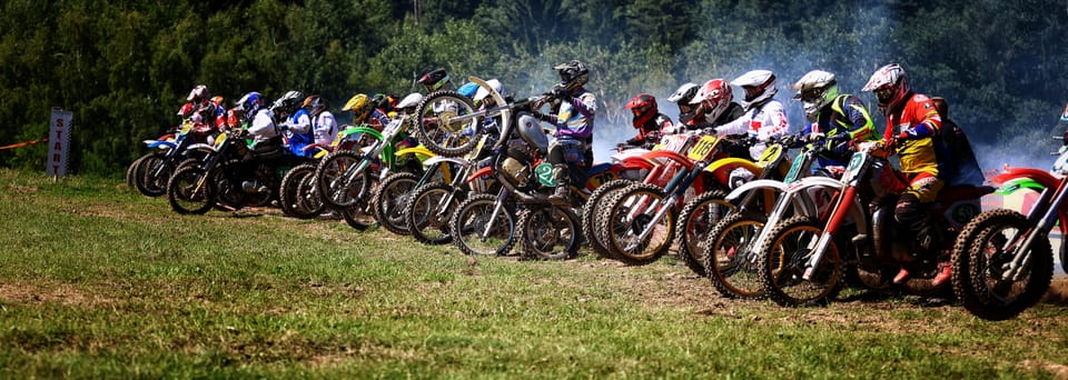 A motocross start line, a row of riders waiting for the gate to drop