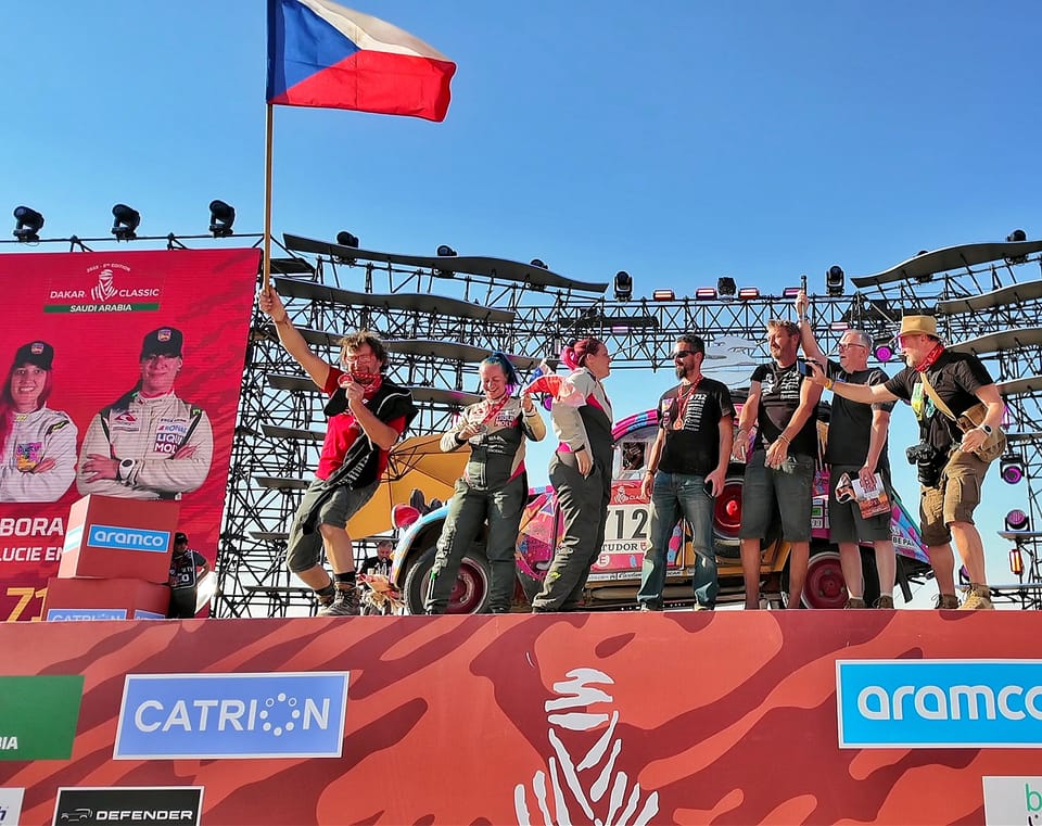 A crew celebrating on the Dakar podium with the Czech flag