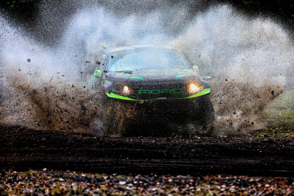 A car through the water splash, throwing up a shattering wall of spray